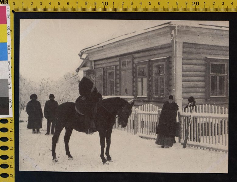 Л.Н. Толстой в зимней одежде, с башлыком на шее, в круглой шапке верхом около дома