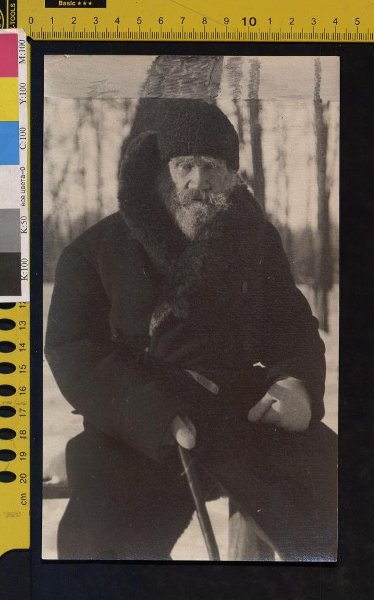 Л.Н. Толстой сидит на скамейке с палкой в правой руке, в зимней одежде с поднятым воротником