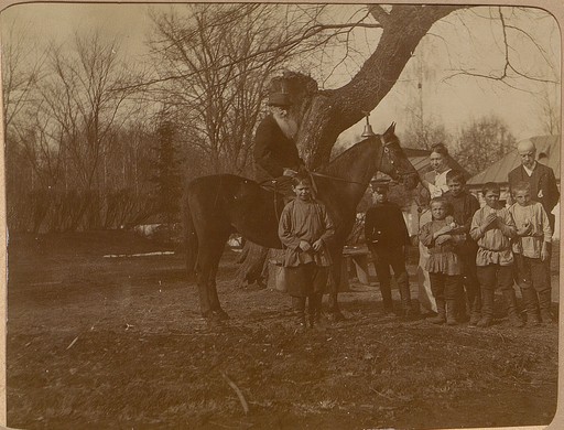 Л.Н. Толстой (верхом), С.А. Толстая и Д.П. Маковицкий с крестьянскими детьми около «дерева бедных»