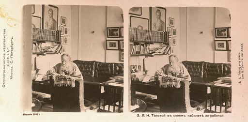 Л.Н. Толстой в белой блузе сидит за письменным столом в кабинете